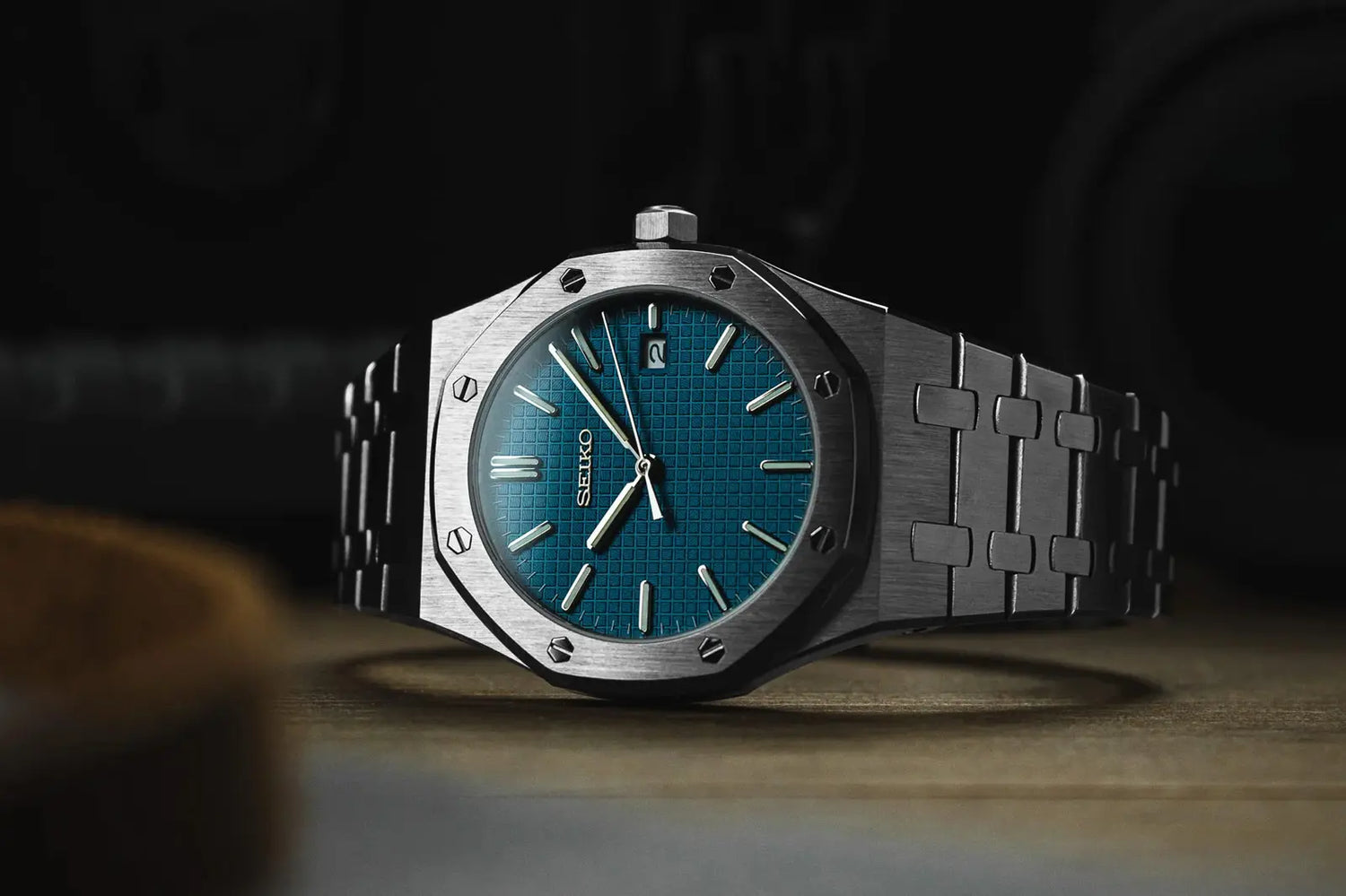 Luxury seiko mod watch with blue face and silver case on a dark background