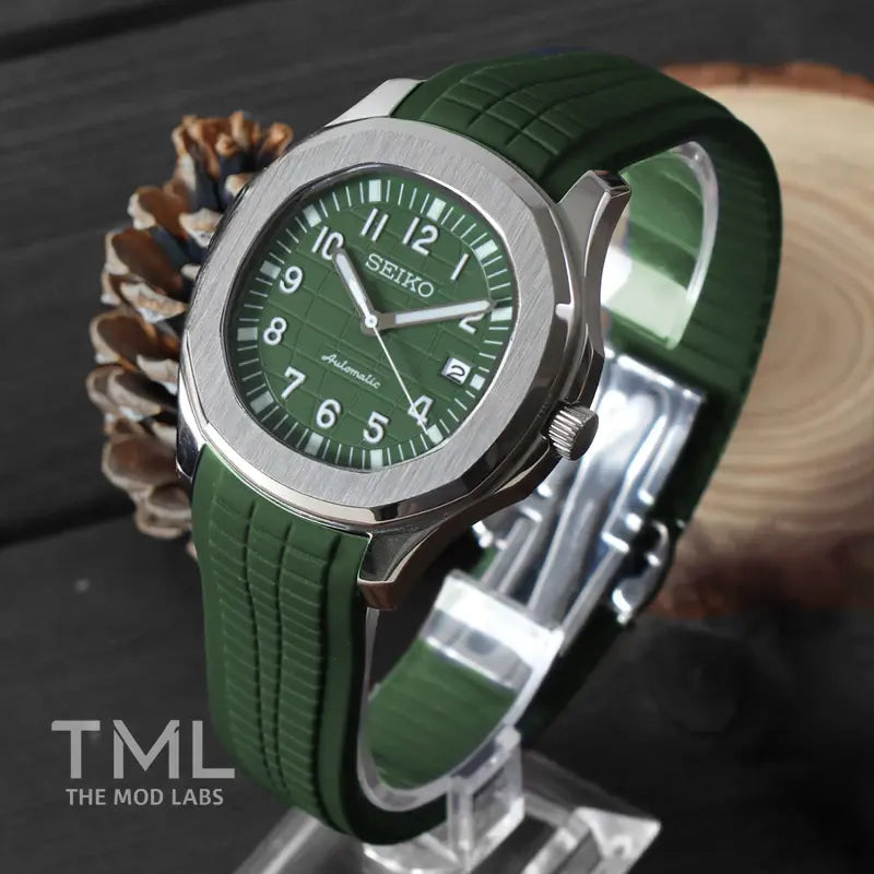 seiko mod aqua naut green watch with a green strap on a wooden surface, branded 'TML The Mod Labs'.