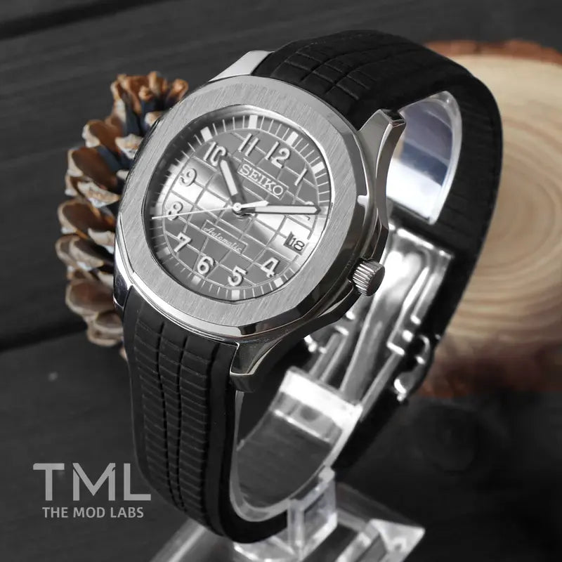 Black Seiko mod aquanaut watch with a textured dial on a wooden surface, branded 'TML The Mod Labs'.